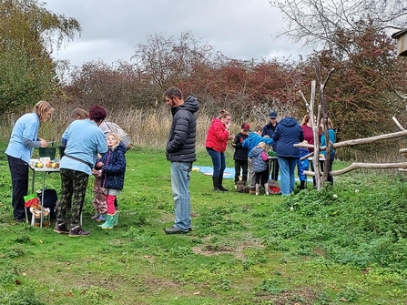 Groups of children and adults taking part in activities in a nature reserve