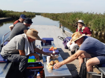 People sit on top a barge sailing down the water