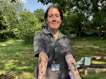 Kaitlyn stands presenting her arms which have been painted many colours