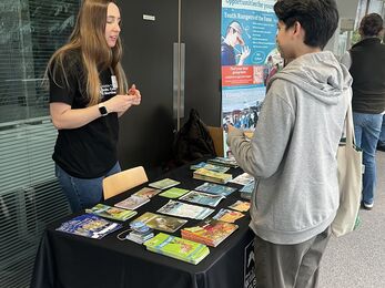 Ellen standing on careers fair stall talking to an enquiring student