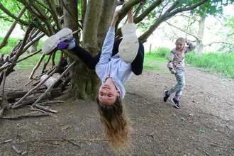 Child swinging from tree