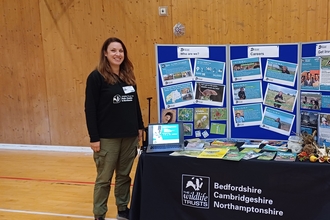 Alison standing at a table with display board 