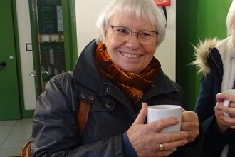 Caroline Lewis holding a mug and smiling