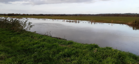 channel of water running between grassed banks