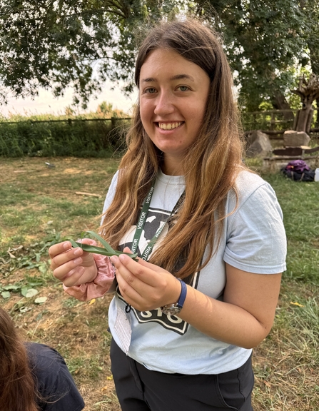 Intern holding a boat made from reeds