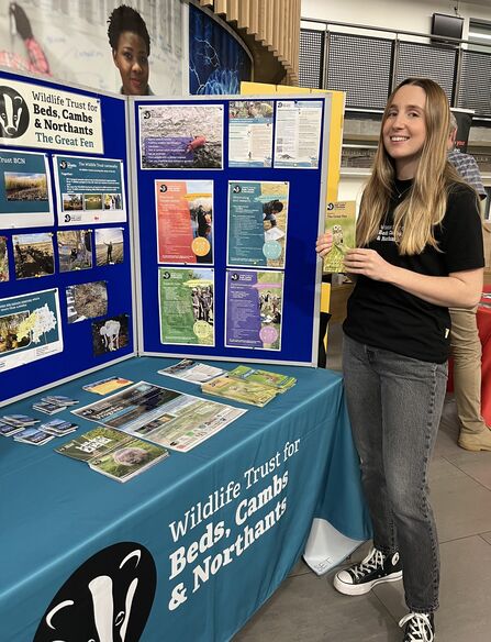 Ellen Standing by a table and display board with posters